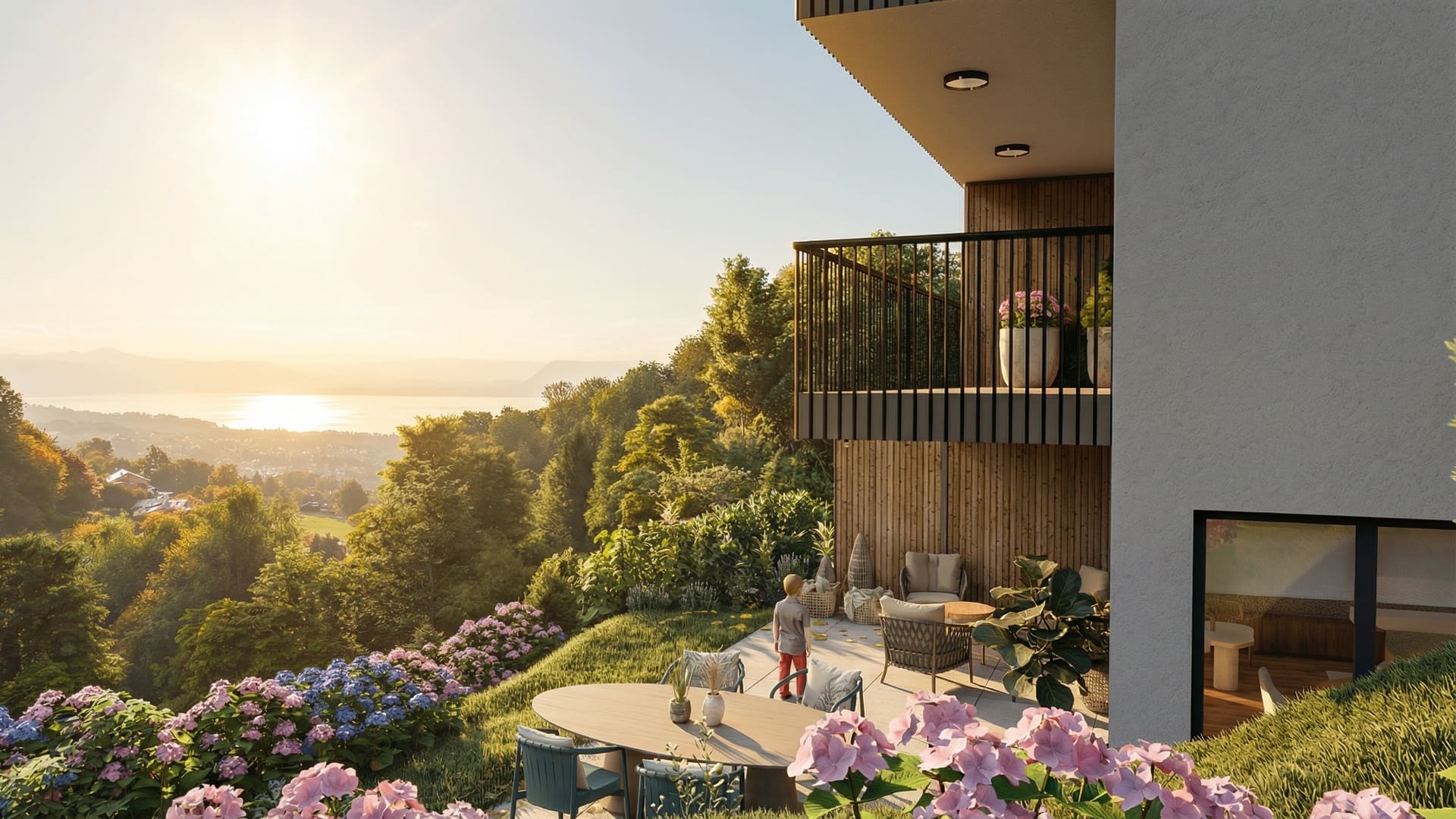Terrasse et jardin paysager d’une villa neuve, avec façade en bois et enduit clair, mobilier de détente et lumière dorée sur les arbres.